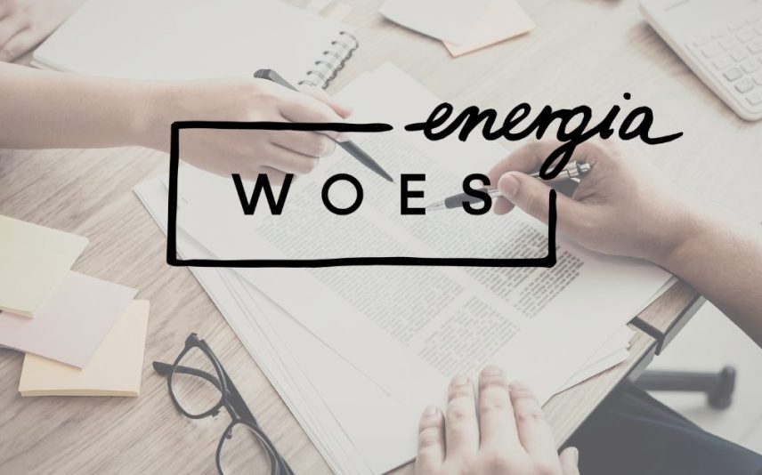zdjęcie dłoni dwóch osób, które trzymają długopisy nad kartkami/ dokumentami. Na przodzie logo projektu WOES Energia
